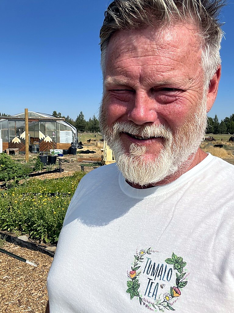 Joel on his Central Oregon herb farm, wearing a Tumalo Tea shirt.